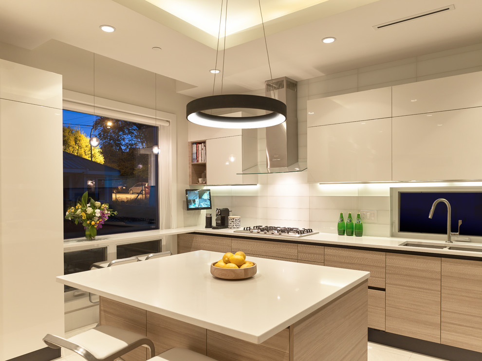 Inspiration for a contemporary u-shaped ceramic tile kitchen remodel in Vancouver with an undermount sink, flat-panel cabinets, quartz countertops, white backsplash, glass tile backsplash, paneled appliances and an island