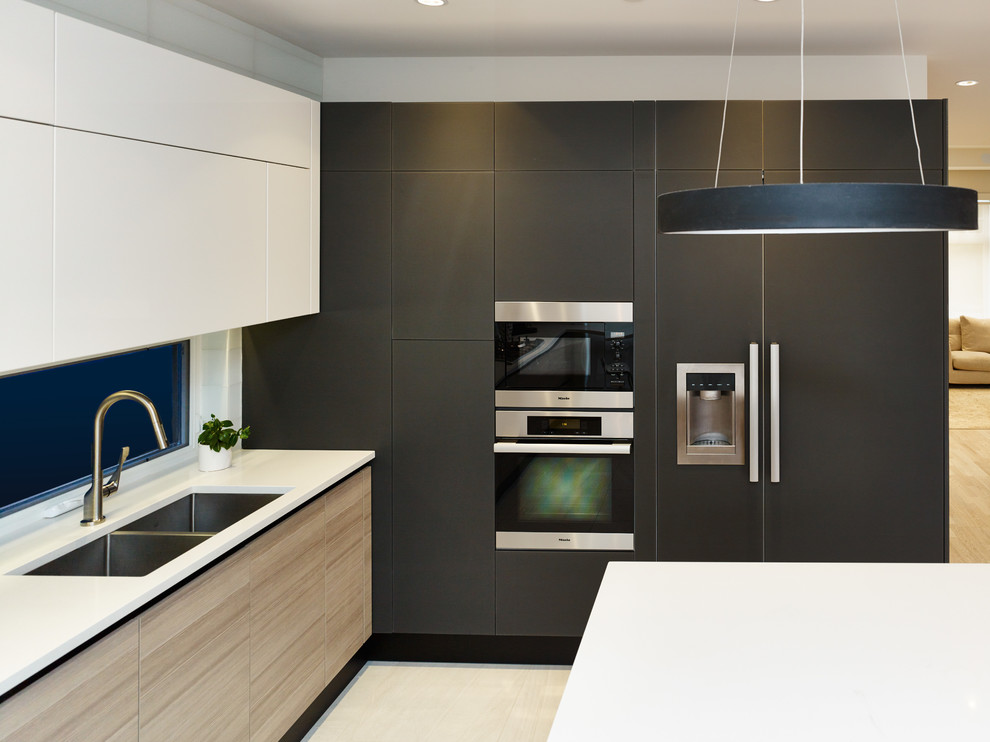 Kitchen - contemporary u-shaped ceramic tile kitchen idea in Vancouver with an undermount sink, flat-panel cabinets, quartz countertops, white backsplash, glass tile backsplash, paneled appliances and an island