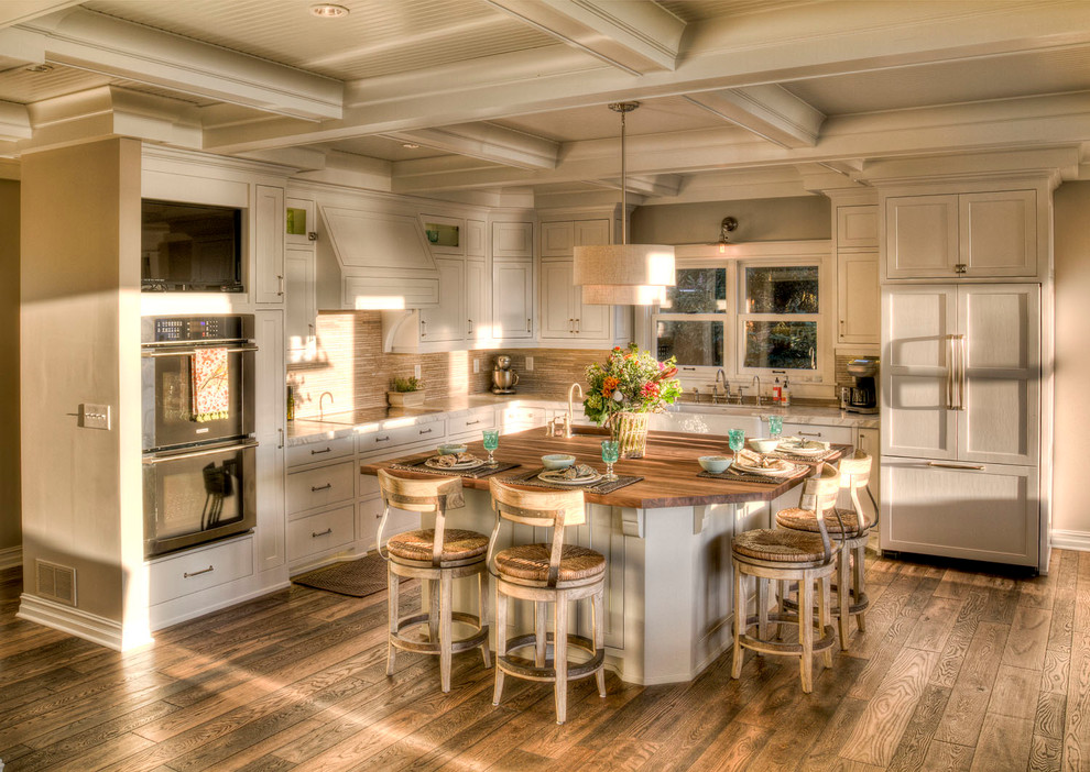 Inspiration för ett stort vintage kök, med vita skåp, en köksö, en undermonterad diskho, luckor med profilerade fronter, träbänkskiva, beige stänkskydd, stänkskydd i stickkakel, integrerade vitvaror, mellanmörkt trägolv och brunt golv