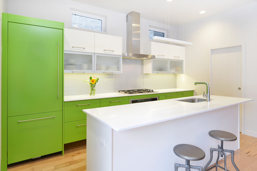 Inspiration for a contemporary galley kitchen in Chicago with a submerged sink, flat-panel cabinets, green cabinets, white splashback, glass sheet splashback and integrated appliances.