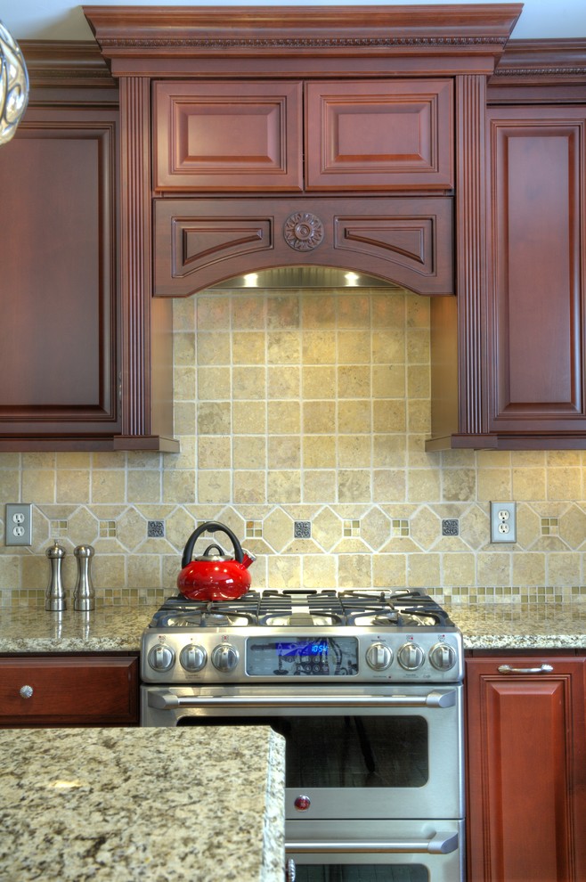 Example of a mid-sized classic u-shaped medium tone wood floor eat-in kitchen design in DC Metro with an undermount sink, raised-panel cabinets, medium tone wood cabinets, granite countertops, beige backsplash, stone tile backsplash, stainless steel appliances and an island