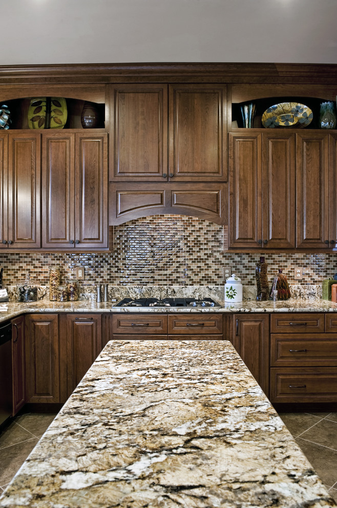 This is an example of a medium sized classic u-shaped kitchen/diner in DC Metro with granite worktops, raised-panel cabinets, medium wood cabinets, multi-coloured splashback, mosaic tiled splashback, a submerged sink, stainless steel appliances, ceramic flooring and an island.