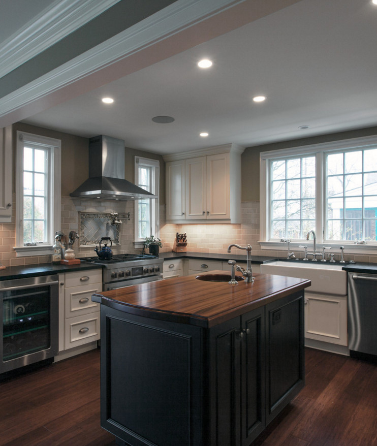 Example of a large classic dark wood floor kitchen design in DC Metro with a farmhouse sink, recessed-panel cabinets, white cabinets, wood countertops, gray backsplash, subway tile backsplash, stainless steel appliances and an island