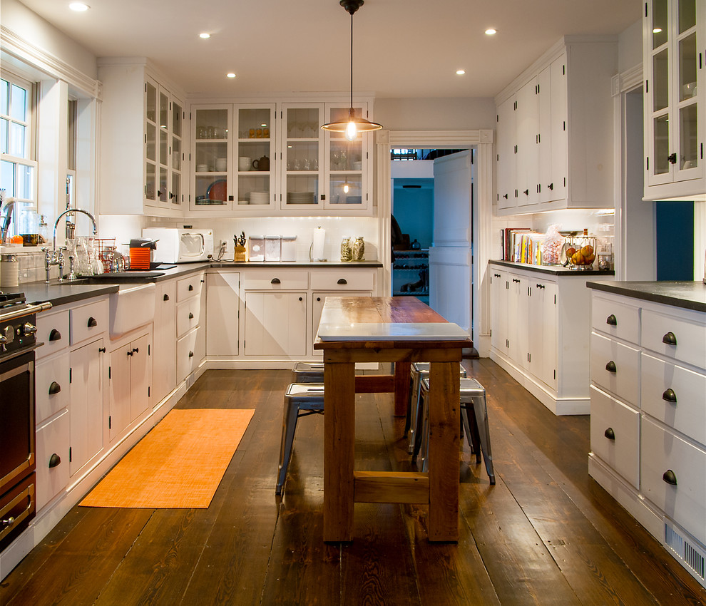 Inspiration for a small farmhouse u-shaped dark wood floor enclosed kitchen remodel in New York with flat-panel cabinets, white cabinets, soapstone countertops, ceramic backsplash, an island and a farmhouse sink