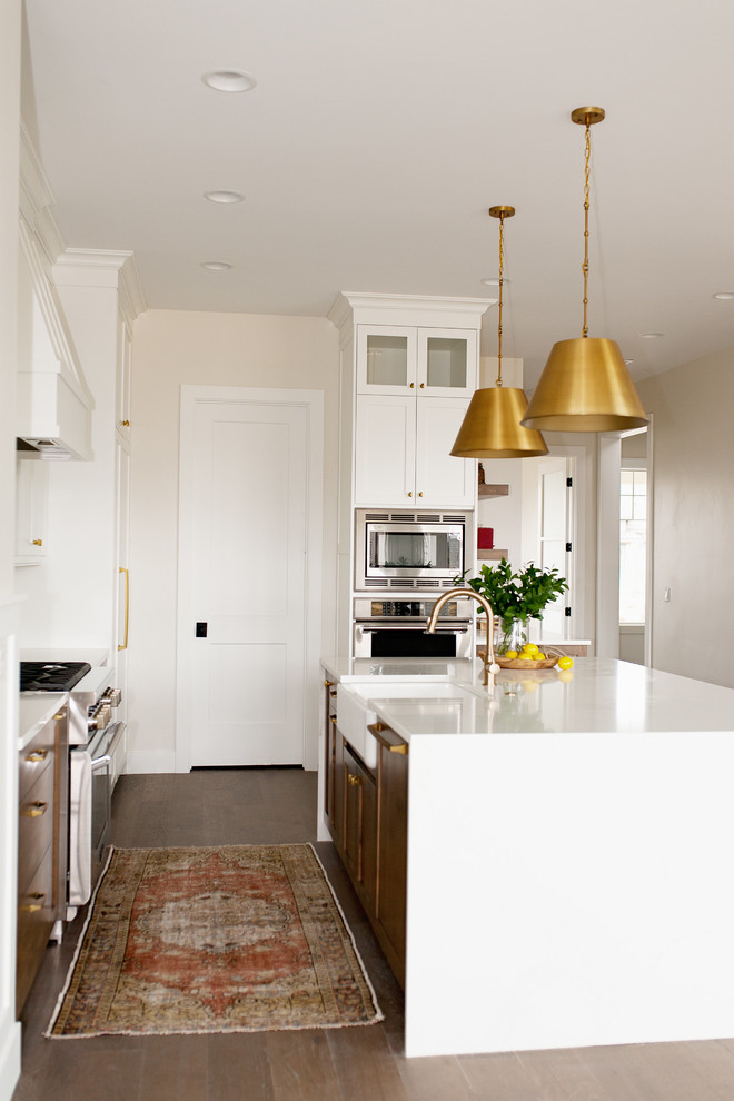 Exempel på ett mellanstort lantligt kök, med en rustik diskho, skåp i shakerstil, skåp i mellenmörkt trä, bänkskiva i kvarts, vitt stänkskydd, stänkskydd i mosaik, rostfria vitvaror, mellanmörkt trägolv och en köksö
