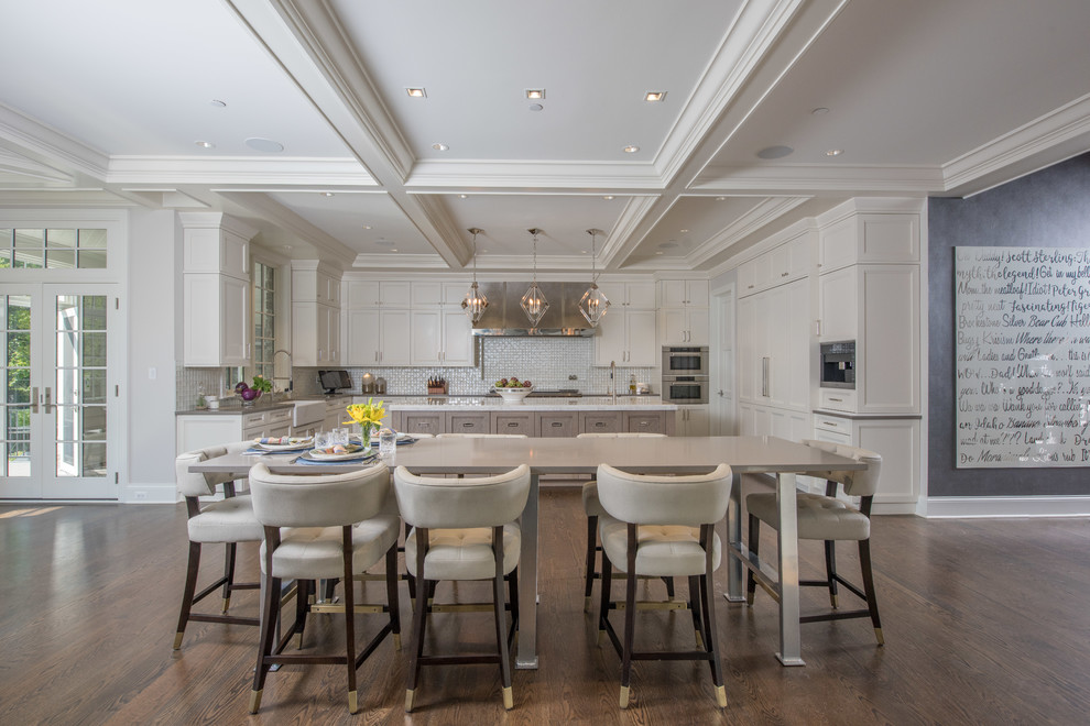 Large elegant u-shaped medium tone wood floor and brown floor open concept kitchen photo in Chicago with a farmhouse sink, beaded inset cabinets, white cabinets, granite countertops, white backsplash, mosaic tile backsplash, stainless steel appliances, an island and beige countertops