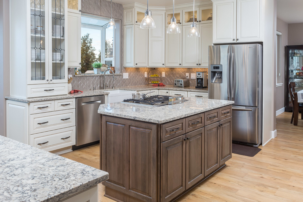 Example of a large classic l-shaped vinyl floor open concept kitchen design in Other with a farmhouse sink, raised-panel cabinets, white cabinets, quartz countertops, gray backsplash, ceramic backsplash, stainless steel appliances and two islands
