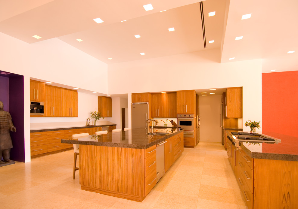 Photo of an expansive contemporary kitchen/diner in Phoenix with a submerged sink, flat-panel cabinets, medium wood cabinets, granite worktops, white splashback, stainless steel appliances, limestone flooring, multiple islands, beige floors and brown worktops.