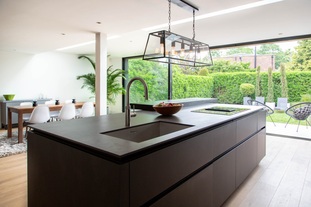 Example of a huge trendy open concept kitchen design in London with an island