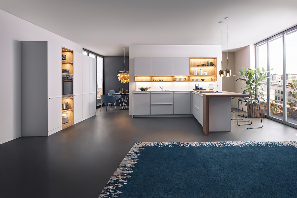Example of a mid-sized minimalist l-shaped kitchen design in New York with flat-panel cabinets, white cabinets, wood countertops and a peninsula