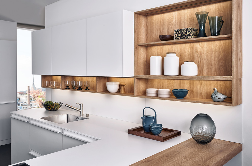 Imagen de cocinas en L minimalista de tamaño medio con armarios con paneles lisos, puertas de armario blancas, encimera de madera y península