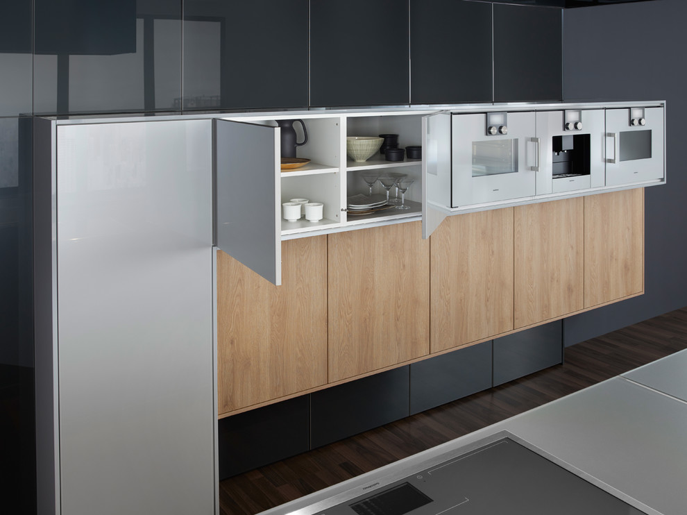 Immagine di una grande cucina design con lavello sottopiano, ante lisce, ante grigie, top in vetro e parquet scuro