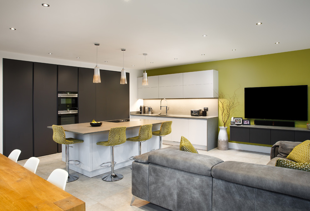 Offene Moderne Küche in L-Form mit Unterbauwaschbecken, flächenbündigen Schrankfronten, weißen Schränken, Kücheninsel, grauem Boden und grauer Arbeitsplatte in Essex