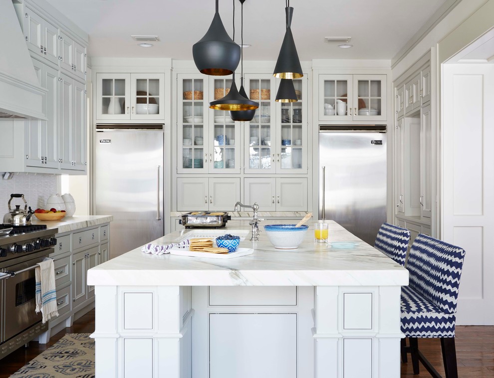 Example of a beach style kitchen design in Jacksonville with white cabinets and an island