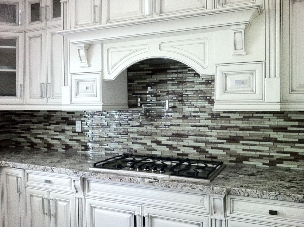Inspiration for a large timeless u-shaped open concept kitchen remodel in Vancouver with an undermount sink, beaded inset cabinets, white cabinets, granite countertops, multicolored backsplash, mosaic tile backsplash, stainless steel appliances and an island