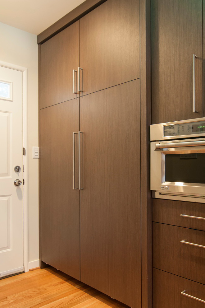 Foto de cocinas en L contemporánea con fregadero bajoencimera, puertas de armario de madera en tonos medios, encimera de cuarzo compacto, salpicadero marrón y electrodomésticos de acero inoxidable