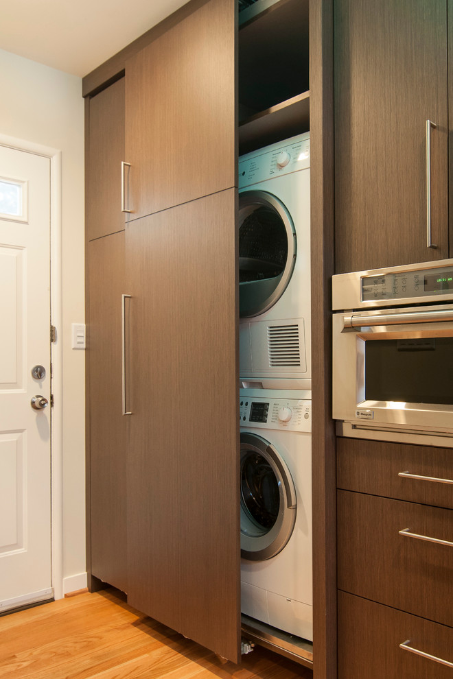 Immagine di una lavanderia minimal con lavello sottopiano, ante in legno bruno, top in quarzo composito e paraspruzzi marrone