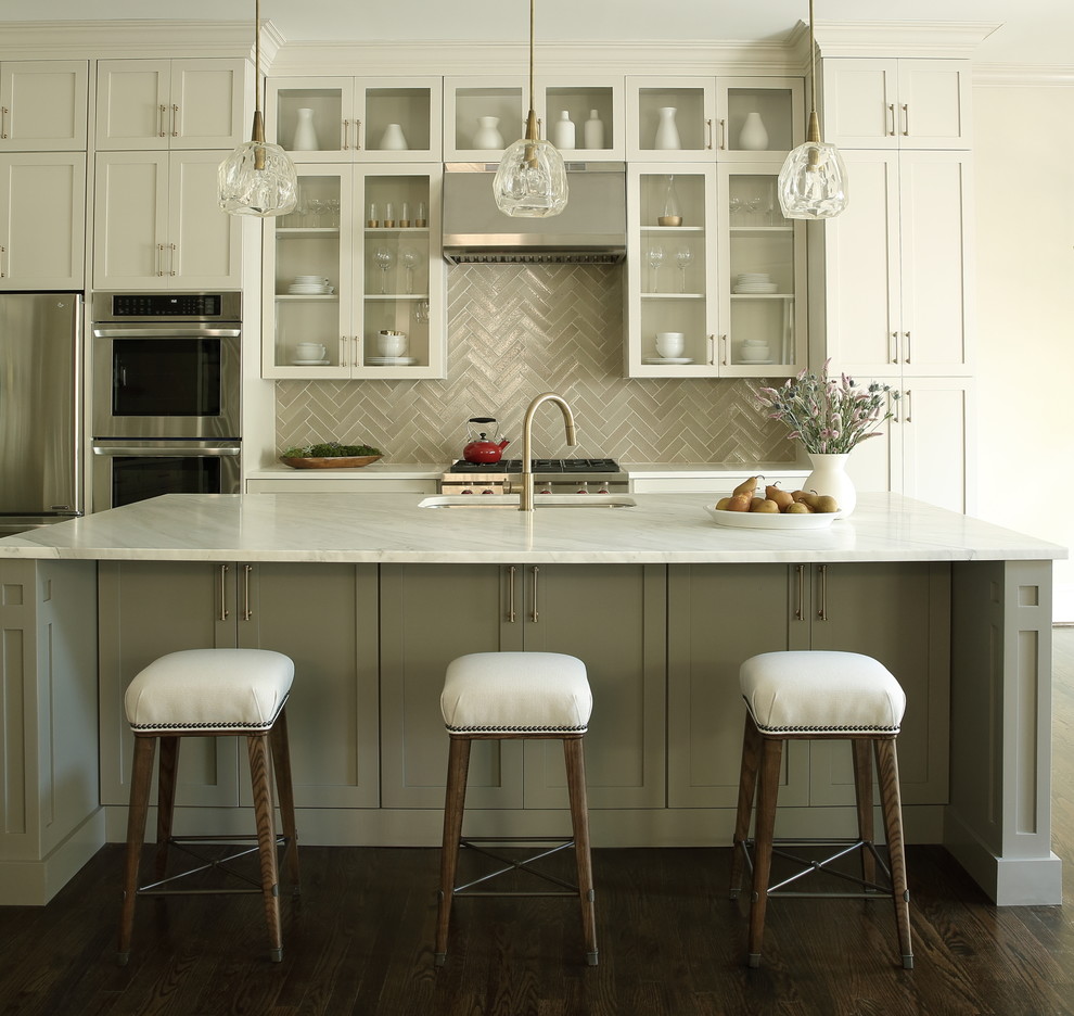 Bild på ett stort 50 tals linjärt kök och matrum, med en nedsänkt diskho, luckor med glaspanel, vita skåp, marmorbänkskiva, beige stänkskydd, rostfria vitvaror, mörkt trägolv, en köksö och brunt golv