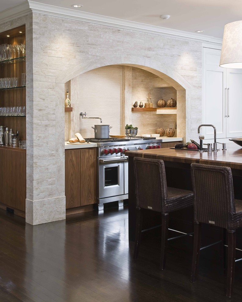 Стильный дизайн: кухня в классическом стиле с техникой из нержавеющей стали, деревянной столешницей и барной стойкой - последний тренд