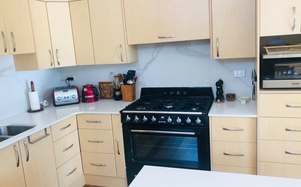 Esempio di una cucina chic di medie dimensioni con lavello sottopiano, top in granito, paraspruzzi bianco, paraspruzzi in gres porcellanato, elettrodomestici neri e top bianco