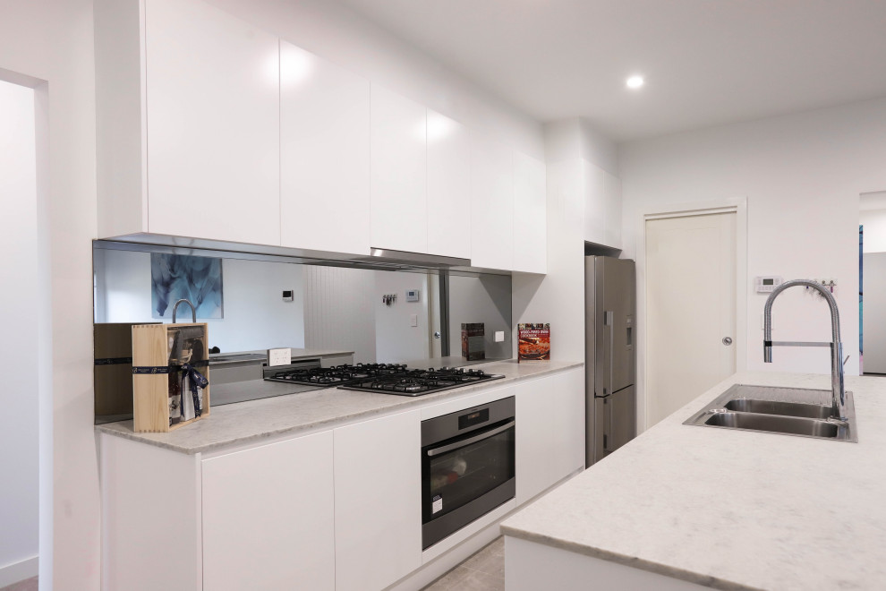 Bild på ett mellanstort funkis vit vitt kök med öppen planlösning, med en dubbel diskho, vita skåp, bänkskiva i koppar, spegel som stänkskydd, rostfria vitvaror, klinkergolv i keramik, en köksö och beiget golv
