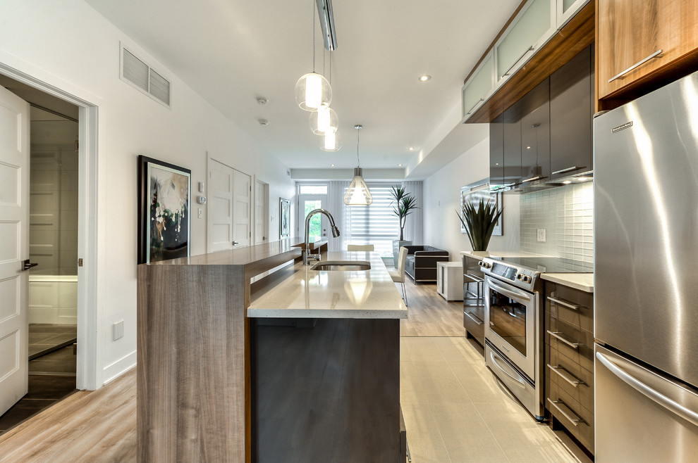 Mittelgroße Moderne Küche mit Unterbauwaschbecken, Glasfronten, Quarzit-Arbeitsplatte, Küchenrückwand in Weiß, Rückwand aus Glasfliesen, Keramikboden und Kücheninsel in Montreal
