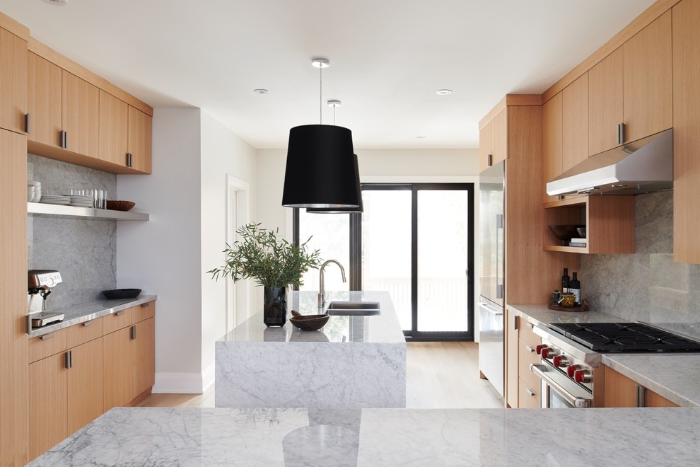 Exempel på ett avskilt, stort modernt u-kök, med en dubbel diskho, släta luckor, skåp i ljust trä, marmorbänkskiva, vitt stänkskydd, stänkskydd i marmor, rostfria vitvaror, ljust trägolv, en halv köksö och brunt golv