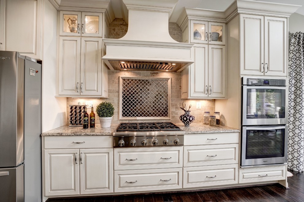 Exempel på ett stort klassiskt flerfärgad flerfärgat kök, med en undermonterad diskho, luckor med upphöjd panel, vita skåp, bänkskiva i kvartsit, stänkskydd med metallisk yta, stänkskydd i keramik, rostfria vitvaror, mörkt trägolv, flera köksöar och brunt golv