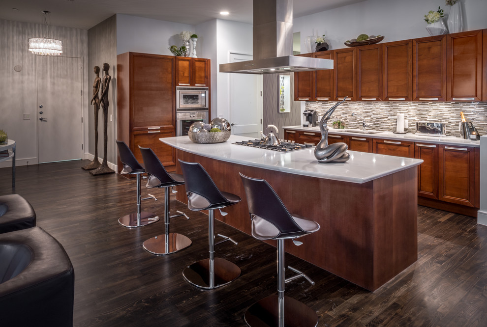 Cette image montre une grande cuisine ouverte design en L et bois brun avec un placard avec porte à panneau encastré, une crédence multicolore, une crédence en mosaïque, parquet foncé et îlot.