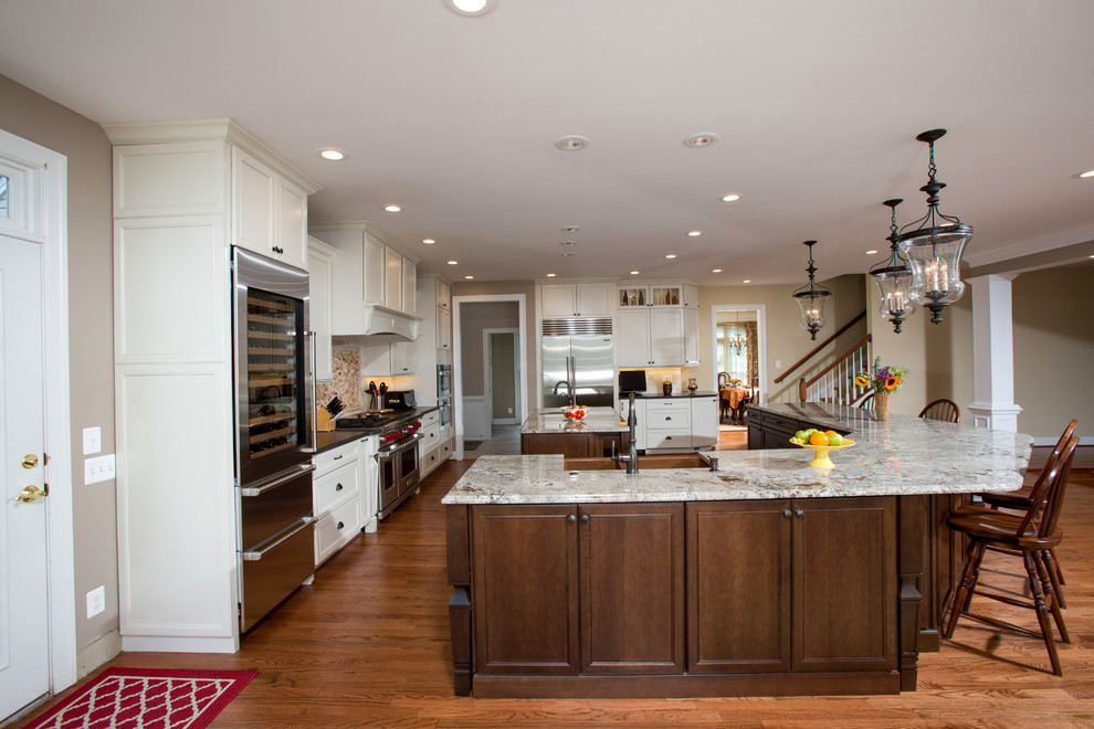 Große Klassische Küche mit weißen Schränken, Granit-Arbeitsplatte, Küchenrückwand in Beige, Küchengeräten aus Edelstahl, hellem Holzboden und zwei Kücheninseln in Washington, D.C.