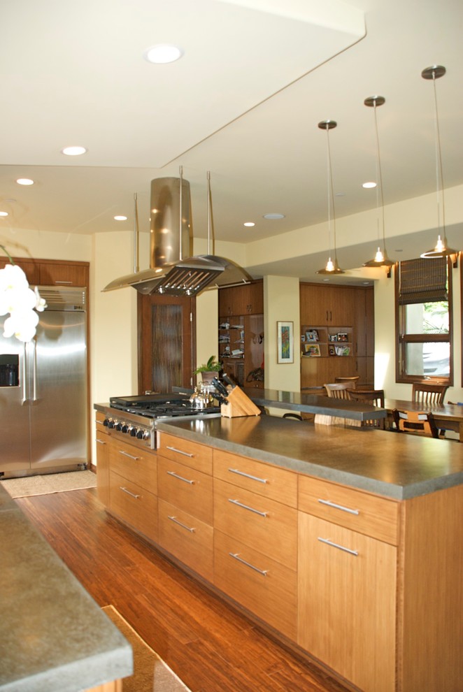 Example of a mid-sized island style galley dark wood floor open concept kitchen design in San Diego with an undermount sink, flat-panel cabinets, light wood cabinets, concrete countertops, beige backsplash, glass tile backsplash, stainless steel appliances and an island