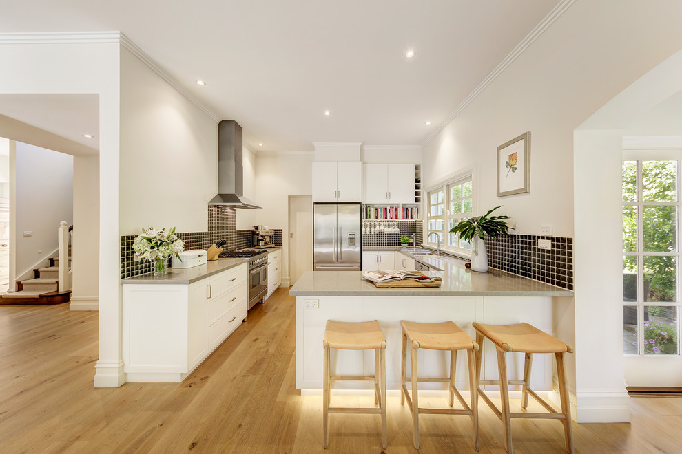Klassische Wohnküche in L-Form mit Unterbauwaschbecken, weißen Schränken, Granit-Arbeitsplatte, Rückwand aus Keramikfliesen und Küchengeräten aus Edelstahl in Melbourne