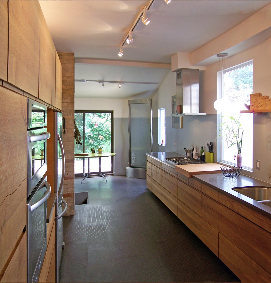 Esempio di una cucina minimalista di medie dimensioni con lavello sottopiano, ante lisce, ante in legno scuro, top in saponaria, paraspruzzi grigio, elettrodomestici in acciaio inossidabile e pavimento in linoleum