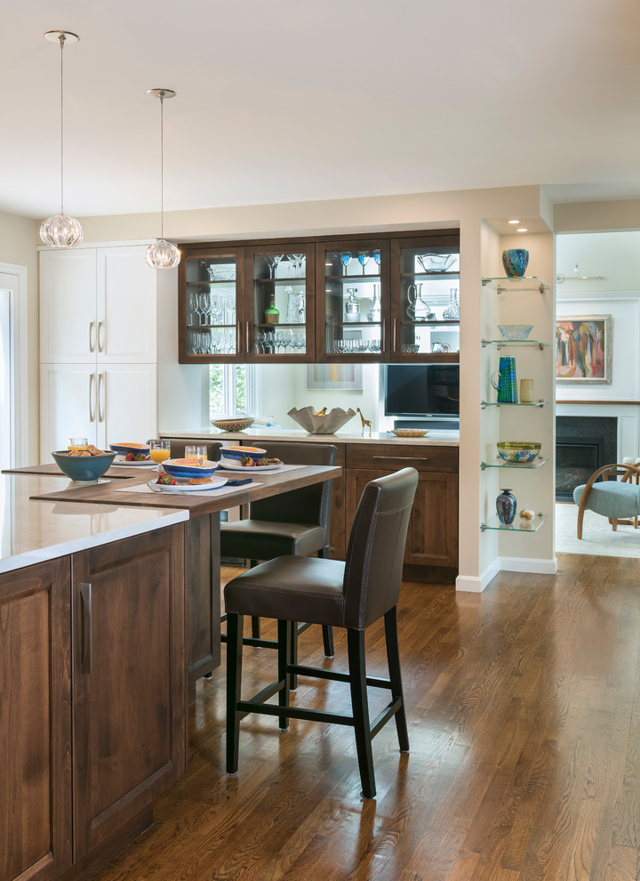 Large transitional l-shaped medium tone wood floor and brown floor open concept kitchen photo in Boston with an undermount sink, shaker cabinets, white cabinets, quartz countertops, beige backsplash, glass tile backsplash, stainless steel appliances, an island and gray countertops