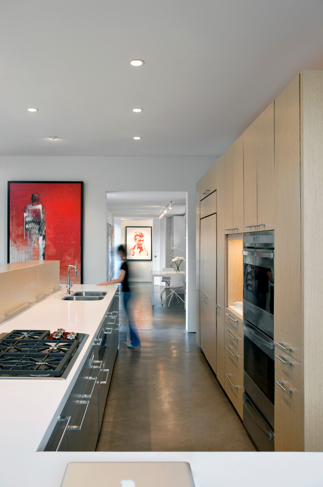 Foto de cocina minimalista con puertas de armario de madera clara y suelo de cemento