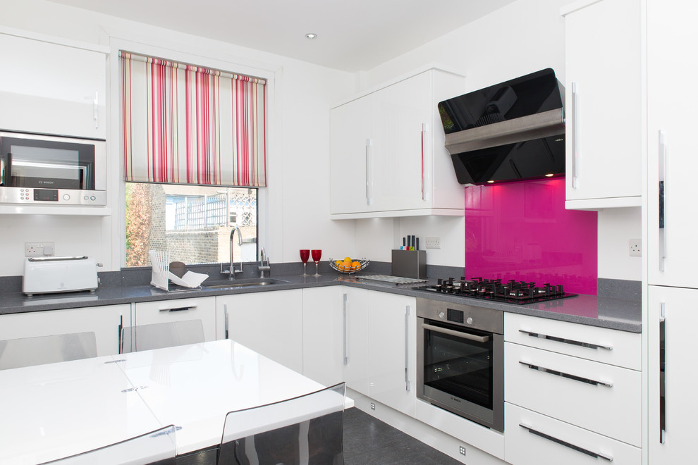 Immagine di una cucina abitabile moderna con lavello da incasso, ante bianche e paraspruzzi rosa