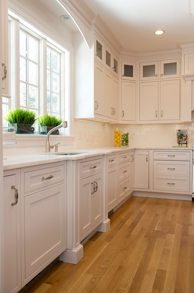 Classic kitchen in Boston with recessed-panel cabinets, white cabinets and an island.