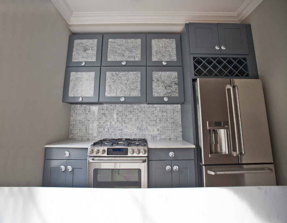 Bild på ett mellanstort funkis kök, med en undermonterad diskho, skåp i shakerstil, grå skåp, bänkskiva i kvarts, grått stänkskydd, stänkskydd i mosaik, rostfria vitvaror, ljust trägolv och en köksö