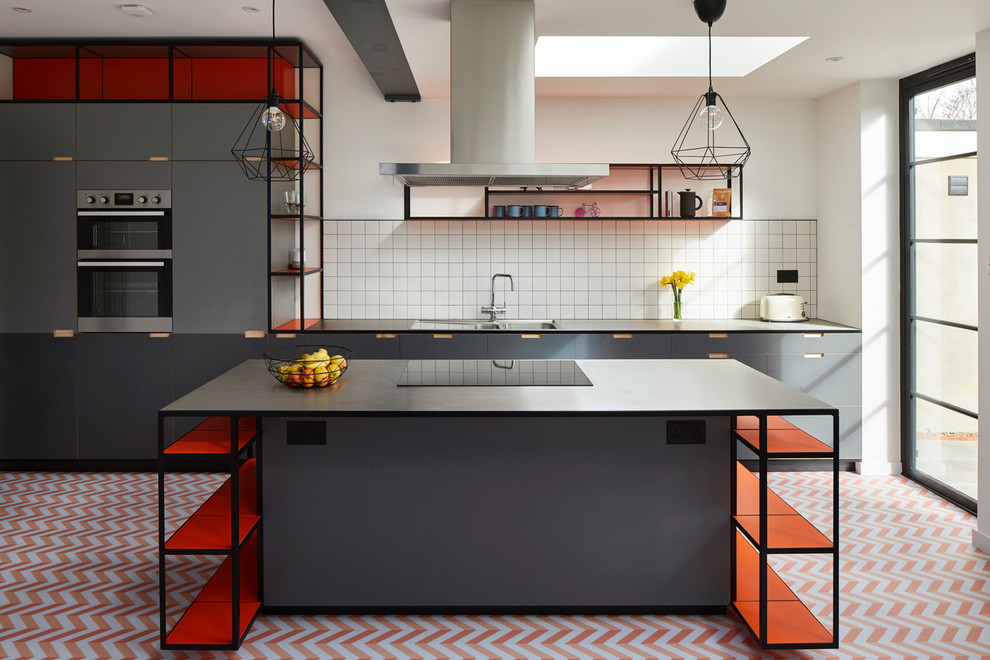 Inredning av ett skandinaviskt kök, med en integrerad diskho, släta luckor, grå skåp, bänkskiva i rostfritt stål, vitt stänkskydd, rostfria vitvaror, en köksö och flerfärgat golv