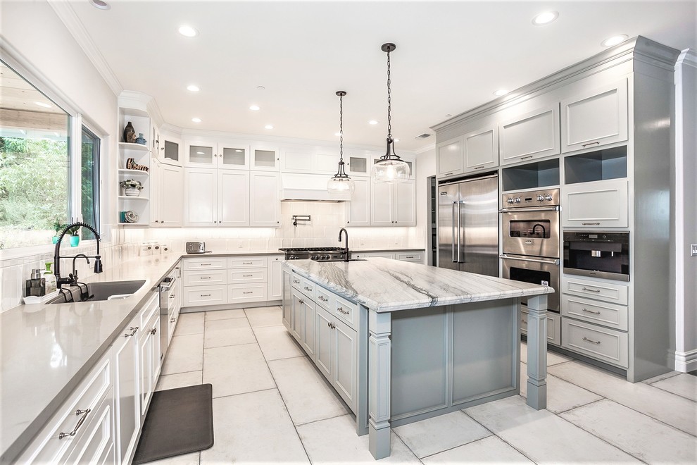 Large trendy u-shaped porcelain tile and white floor eat-in kitchen photo in Los Angeles with an undermount sink, shaker cabinets, gray cabinets, marble countertops, white backsplash, ceramic backsplash, stainless steel appliances, an island and gray countertops