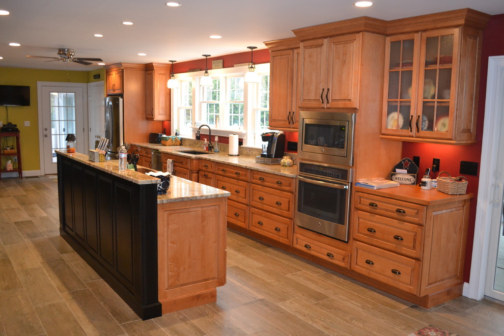 Immagine di una grande cucina chic con lavello sottopiano, ante con bugna sagomata, ante in legno scuro, top in granito e elettrodomestici in acciaio inossidabile