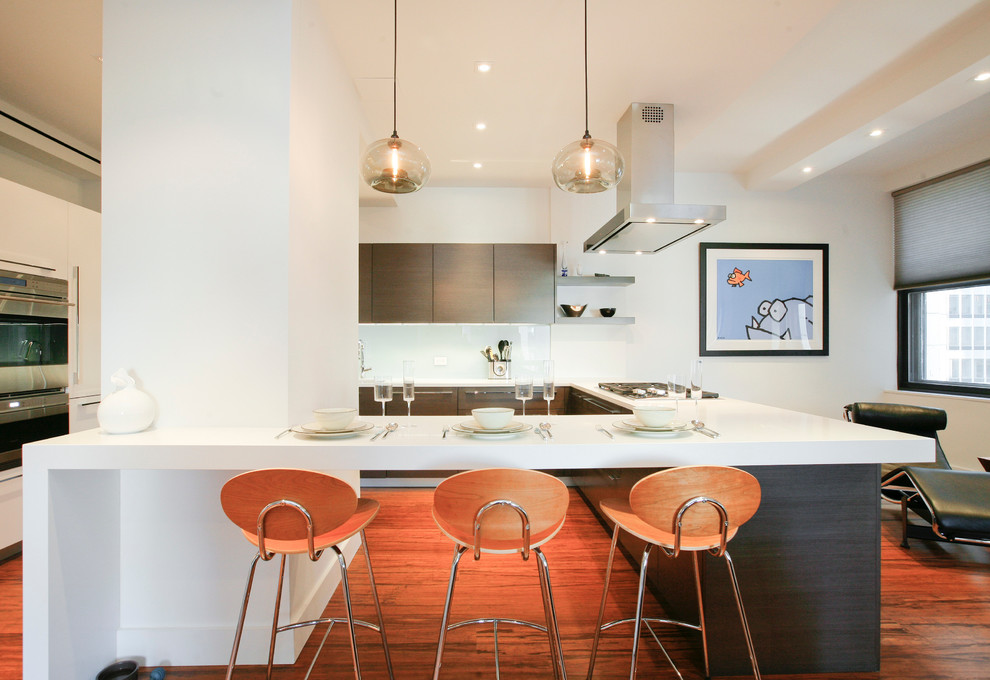 Moderne Küche mit flächenbündigen Schrankfronten, dunklen Holzschränken, Küchenrückwand in Weiß, Küchengeräten aus Edelstahl, Glasrückwand und hellem Holzboden in New York
