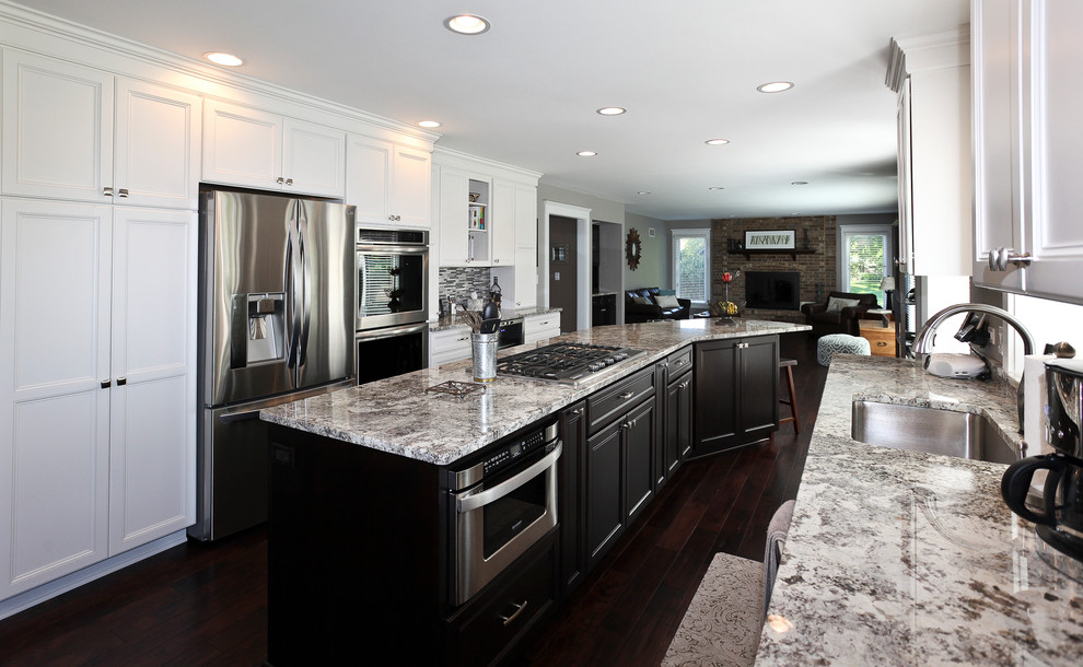 Kitchen - large transitional galley dark wood floor and brown floor kitchen idea in Chicago with an undermount sink, stainless steel appliances, recessed-panel cabinets, white cabinets, granite countertops, multicolored backsplash, glass tile backsplash and an island