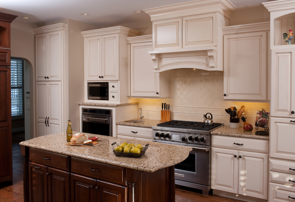 Eat-in kitchen - traditional u-shaped eat-in kitchen idea in Chicago with a single-bowl sink, raised-panel cabinets, white cabinets, granite countertops, white backsplash, ceramic backsplash and stainless steel appliances
