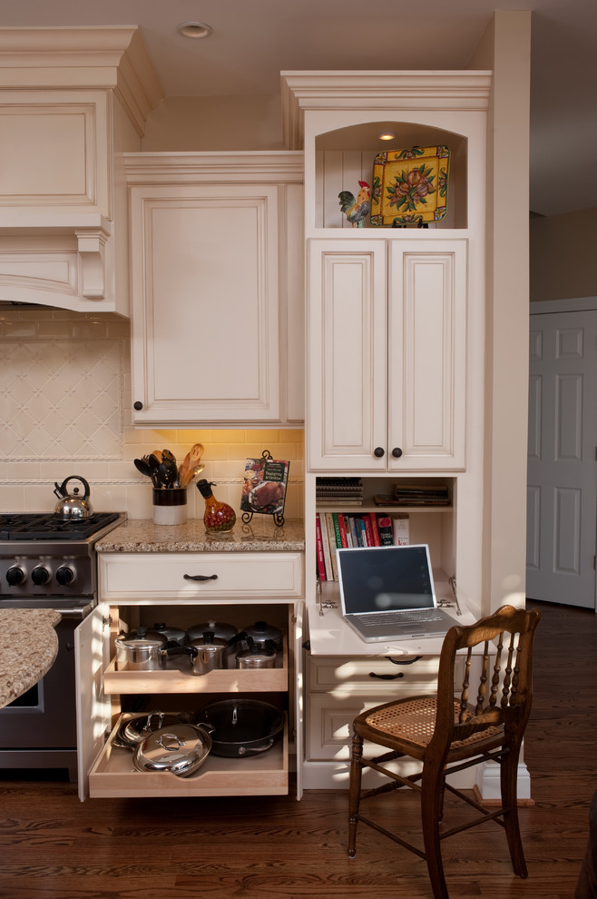 Klassische Wohnküche in U-Form mit Waschbecken, profilierten Schrankfronten, weißen Schränken, Granit-Arbeitsplatte, Küchenrückwand in Weiß, Rückwand aus Keramikfliesen und Küchengeräten aus Edelstahl in Chicago