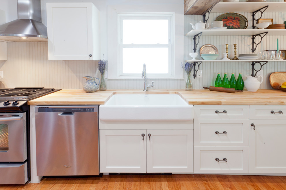 Bild på ett eklektiskt linjärt kök med öppen planlösning, med en rustik diskho, skåp i shakerstil, vita skåp, träbänkskiva, grått stänkskydd och rostfria vitvaror