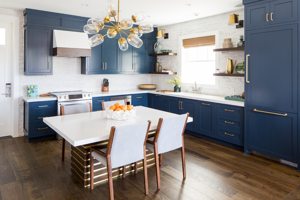 Foto de cocina comedor sin isla con armarios estilo shaker, puertas de armario azules, electrodomésticos con paneles, suelo de madera oscura, suelo marrón y encimeras blancas