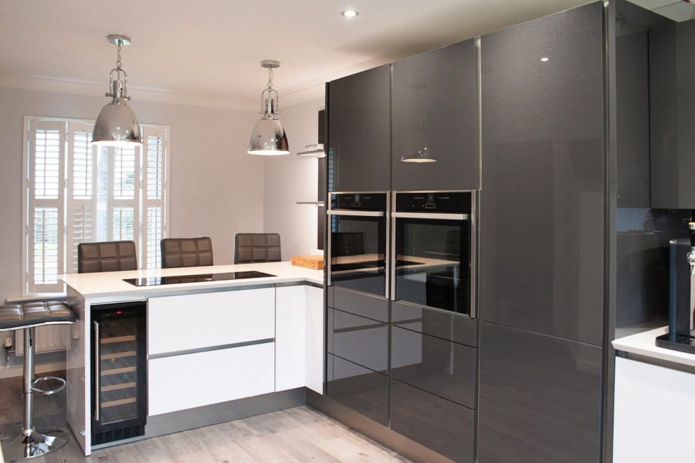 Medium sized modern kitchen in Essex with white cabinets and quartz worktops.