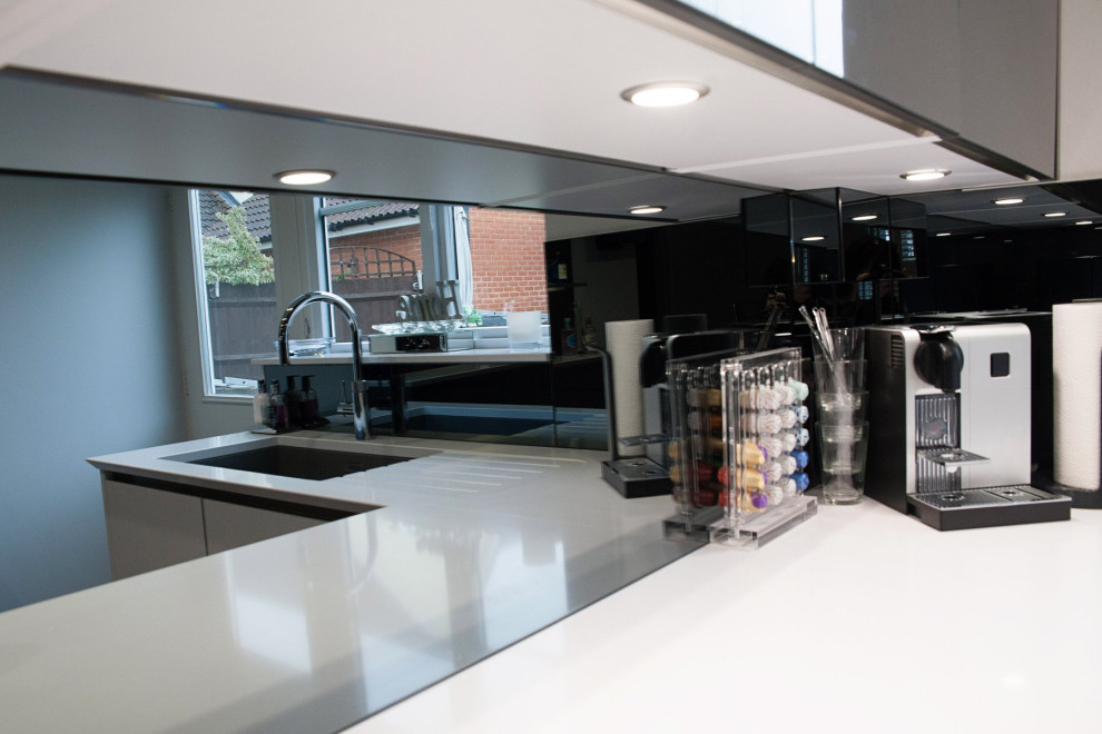 На фото: кухня среднего размера в стиле модернизм с белыми фасадами и столешницей из кварцита