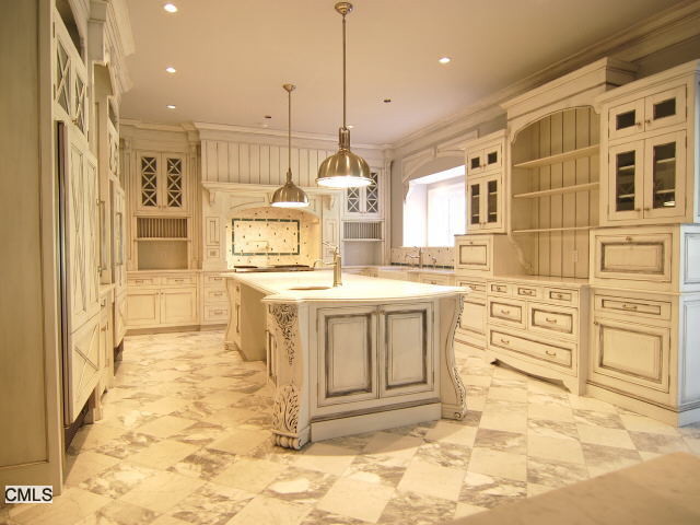 Klassisk inredning av ett mellanstort kök, med en undermonterad diskho, skåp i slitet trä, färgglada vitvaror, klinkergolv i porslin och en köksö